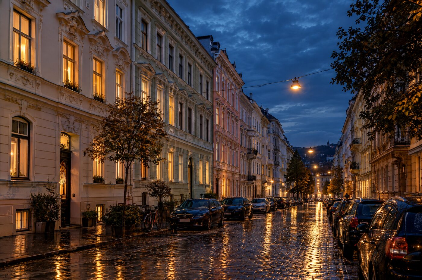 Sanierte Gründerzeitfassaden in einer Wiener Straße bei Abenddämmerung